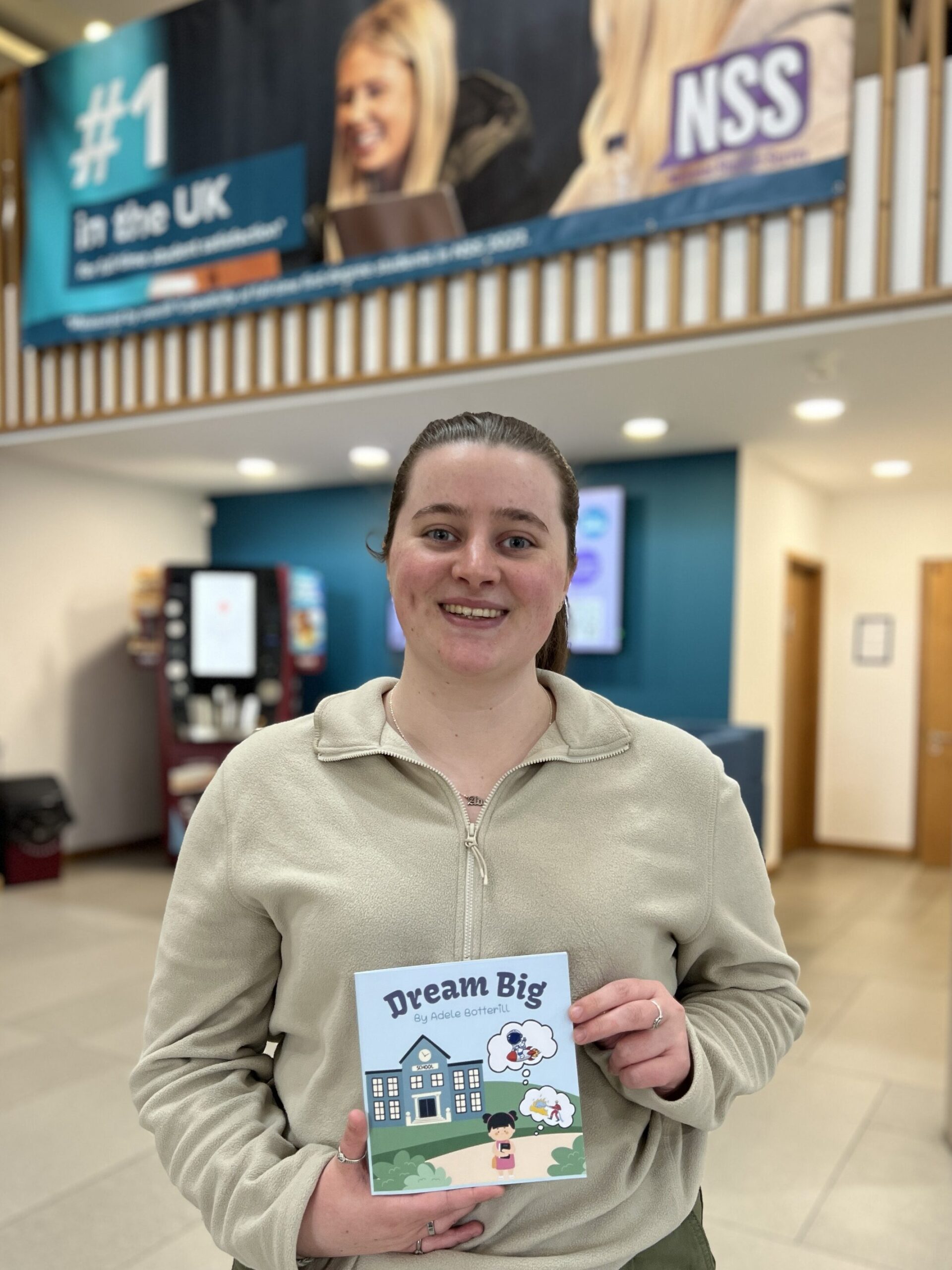 An image of Applied Humanities student, Adele Botterill holding her published book on Amazon called 'Dream Big'